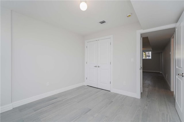 unfurnished bedroom with light hardwood / wood-style floors and a closet