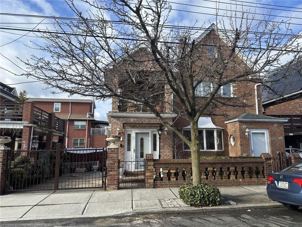 view of front of home with a fenced front yard, a gate, and brick siding