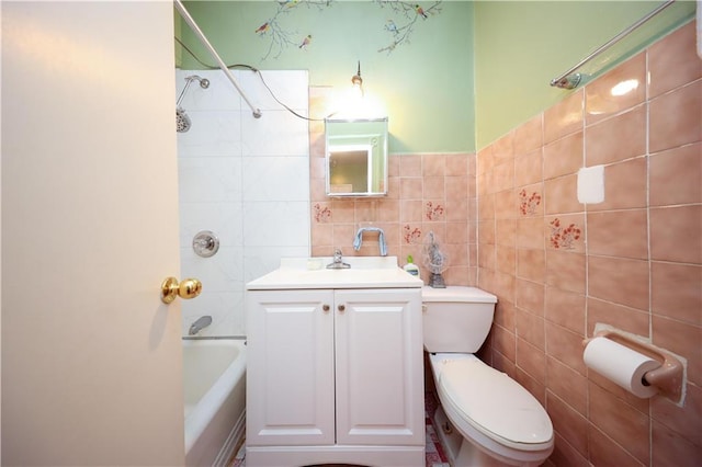 full bathroom featuring vanity, toilet, tile walls, and tiled shower / bath combo