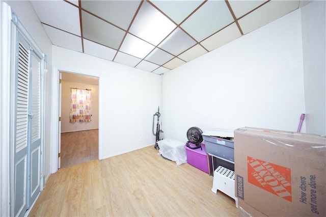 miscellaneous room with a drop ceiling and hardwood / wood-style floors