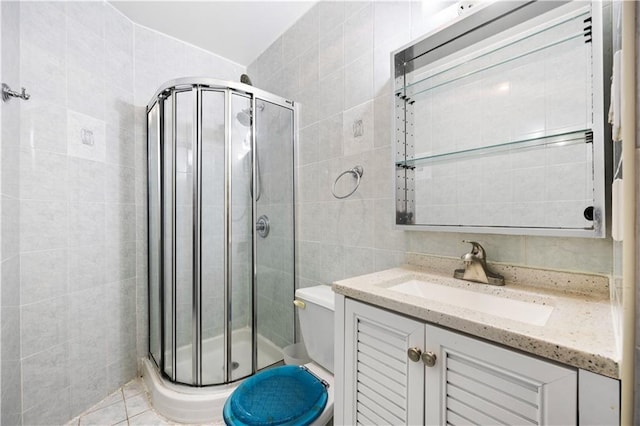 bathroom with toilet, vanity, tile walls, and walk in shower