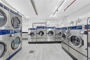 community laundry room with light wood-style flooring, separate washer and dryer, and stacked washer / dryer