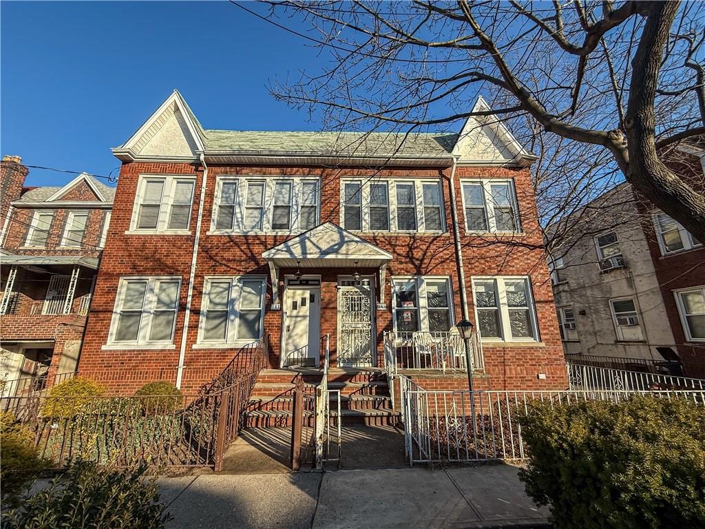 view of property with a fenced front yard and brick siding