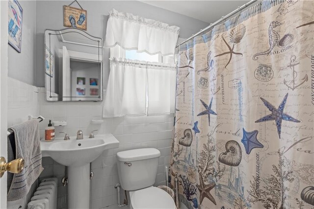 bathroom with toilet, tile walls, sink, radiator heating unit, and a shower with shower curtain