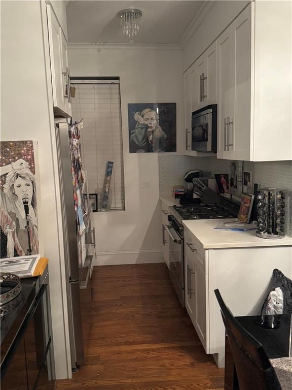 kitchen with stainless steel appliances, crown molding, dark wood-type flooring, and white cabinets