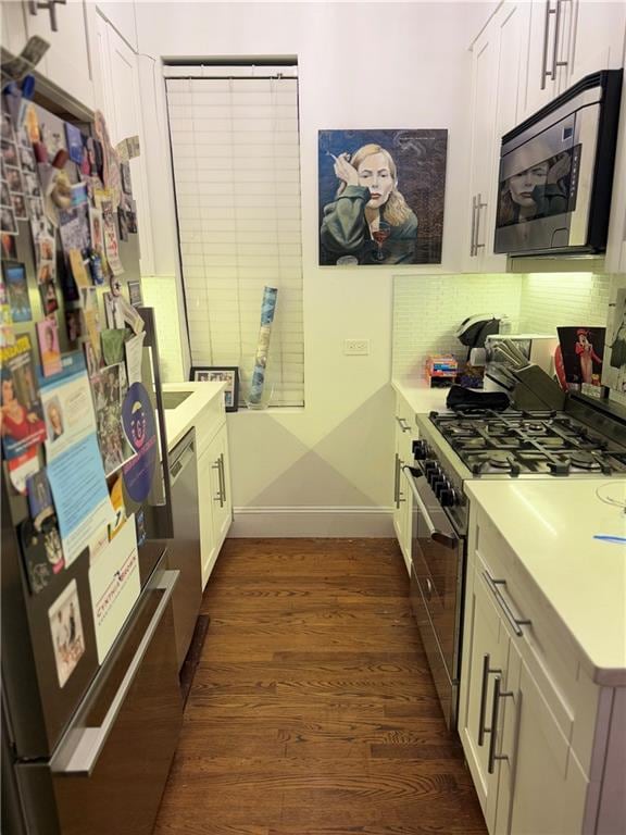 kitchen with backsplash, stainless steel appliances, dark hardwood / wood-style flooring, and white cabinets