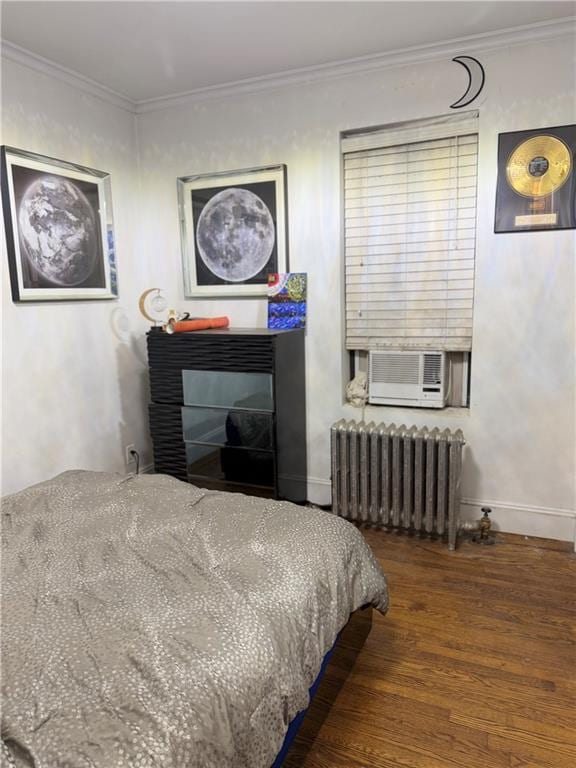 bedroom with cooling unit, radiator, wood-type flooring, and ornamental molding