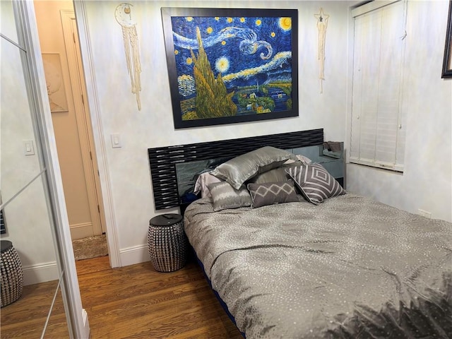 bedroom featuring dark wood-type flooring and a fireplace