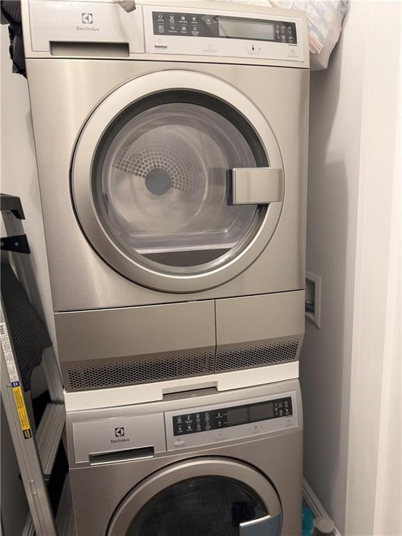 24-75 38th St Unit 10D, Astoria, NY 11101 - laundry room featuring stacked washer and clothes dryer and baseboards