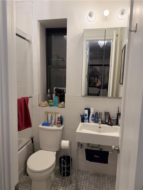 bathroom featuring tile walls, tile patterned floors, and toilet