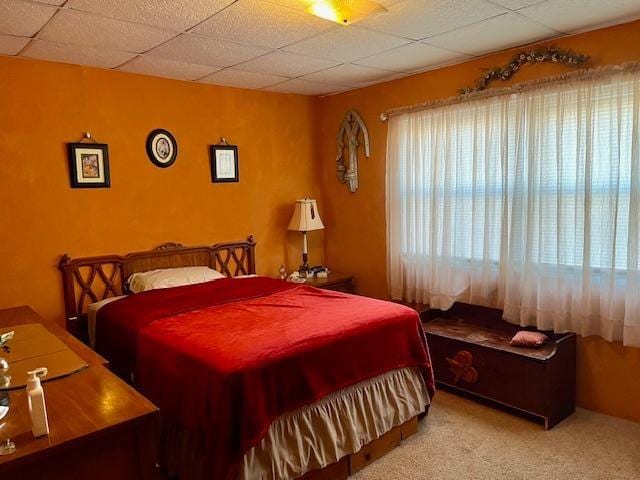 carpeted bedroom featuring multiple windows and a paneled ceiling