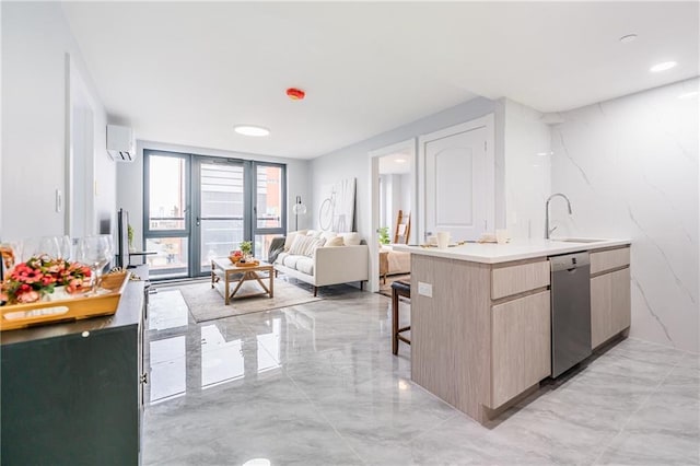 kitchen with sink, a breakfast bar area, dishwasher, a wall unit AC, and light brown cabinetry