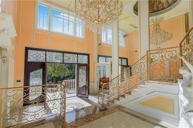 entrance foyer featuring an inviting chandelier, a towering ceiling, and stairway