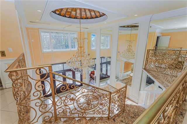 interior space featuring ornamental molding, a wainscoted wall, a notable chandelier, and tile patterned flooring