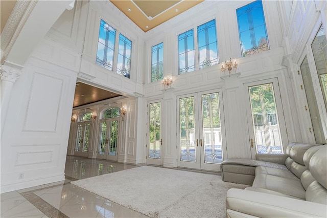 unfurnished sunroom featuring french doors and an inviting chandelier