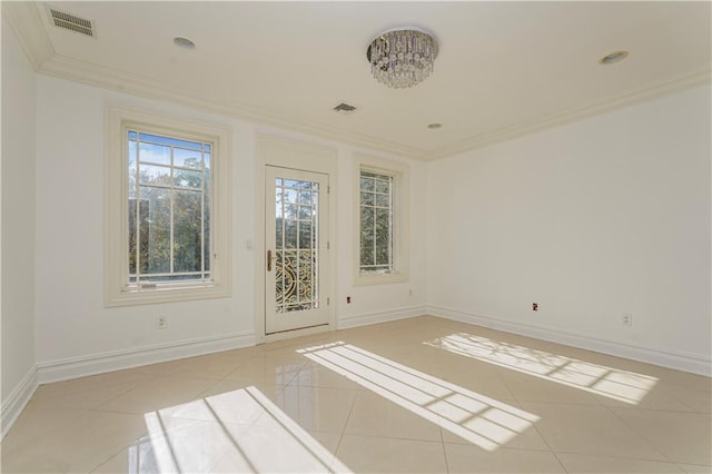 spare room featuring light tile patterned floors, visible vents, ornamental molding, and baseboards
