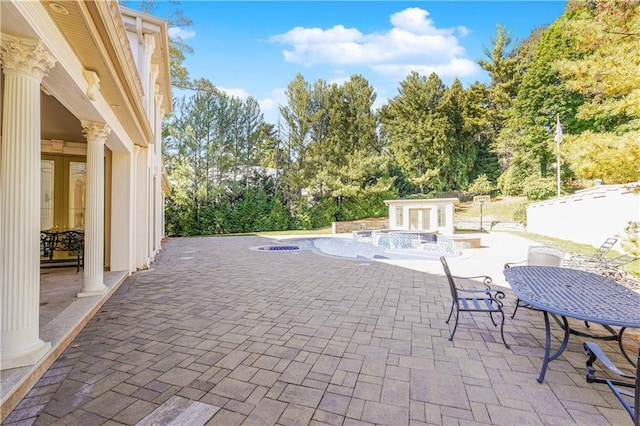 view of patio / terrace with an outbuilding, outdoor dining space, and an outdoor pool