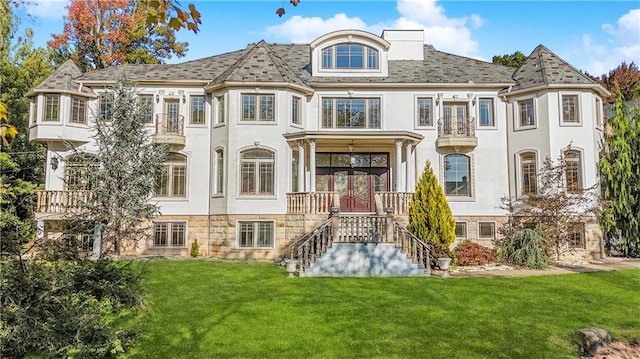 view of front of property with a front lawn, stucco siding, and french doors