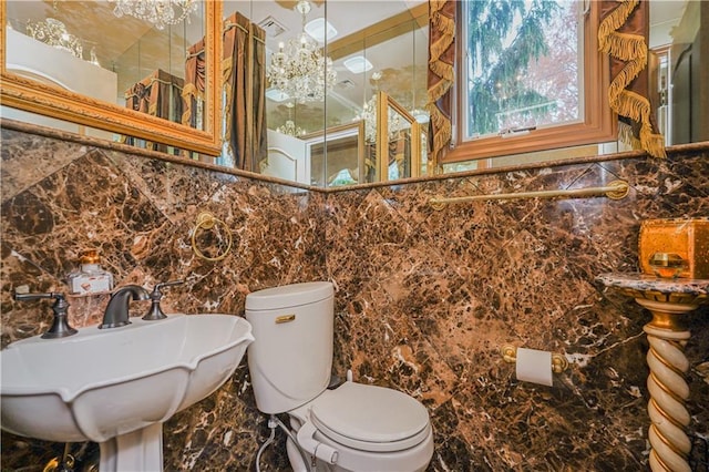 bathroom featuring sink, tile walls, and toilet