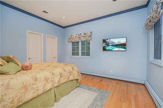 bedroom with a baseboard radiator, ornamental molding, light wood-type flooring, baseboards, and visible vents
