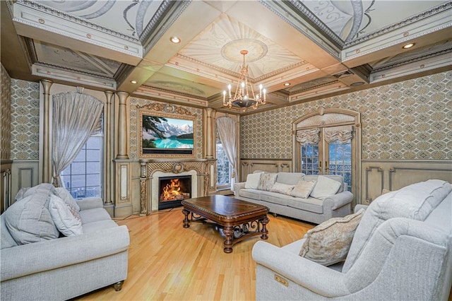 living room featuring hardwood / wood-style floors, coffered ceiling, a notable chandelier, ornamental molding, and beamed ceiling