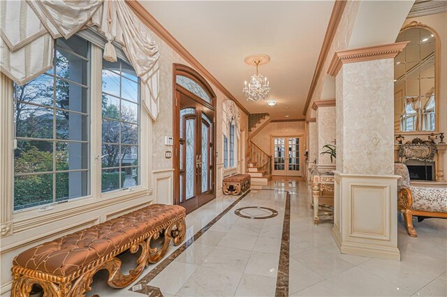 foyer featuring crown molding, an inviting chandelier, stairway, and french doors