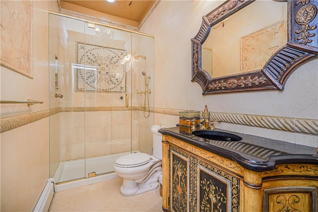 bathroom with toilet, a baseboard heating unit, a shower stall, and vanity