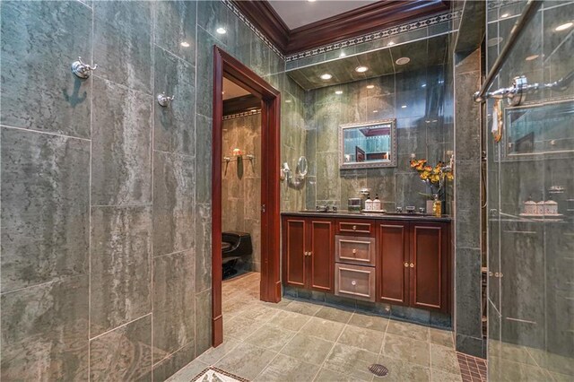 interior space featuring ornamental molding, tile walls, double vanity, and tiled shower
