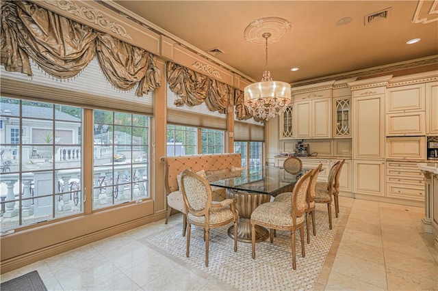 dining room with an inviting chandelier, light tile patterned floors, and crown molding