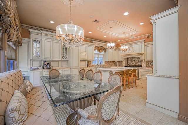 dining room with ornamental molding, sink, light tile patterned flooring, and an inviting chandelier