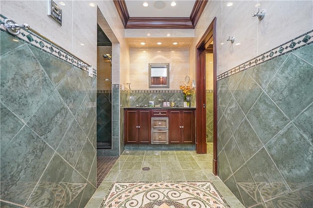 bathroom with walk in shower, tile patterned floors, crown molding, tile walls, and vanity