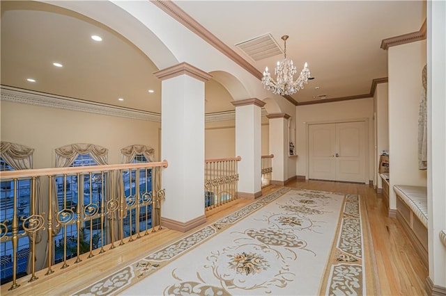 hallway with recessed lighting, wood finished floors, arched walkways, decorative columns, and visible vents