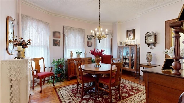 dining room featuring ornamental molding, a chandelier, and light wood-type flooring