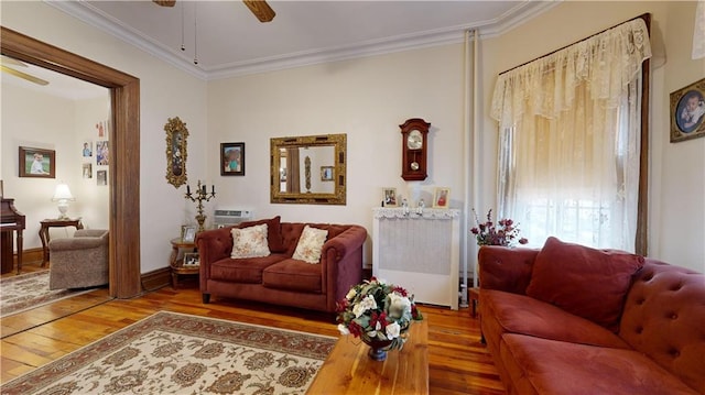 living room featuring ornamental molding, ceiling fan, and wood-type flooring