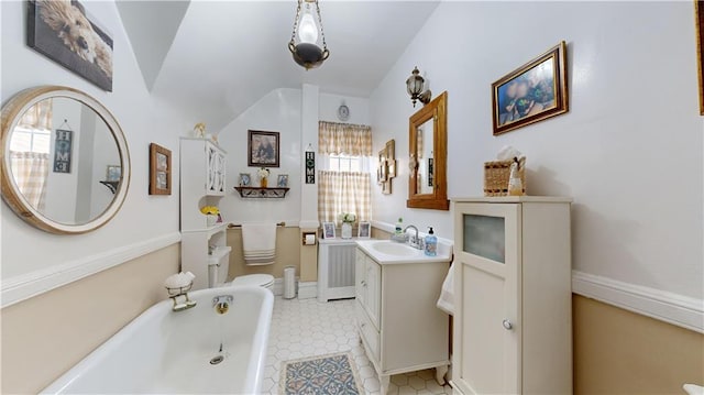 bathroom with vanity, toilet, and a tub to relax in