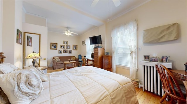 bedroom with ornamental molding, radiator heating unit, light hardwood / wood-style floors, and ceiling fan