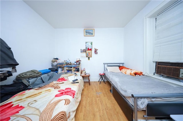 bedroom featuring light wood-type flooring and cooling unit