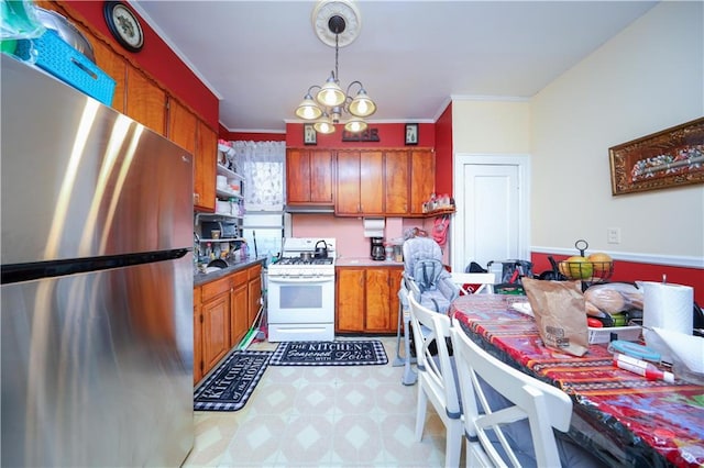 kitchen with a notable chandelier, white gas range oven, stainless steel refrigerator, hanging light fixtures, and ornamental molding