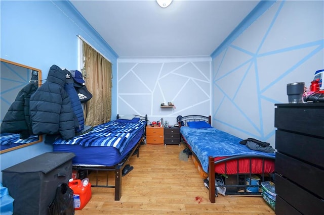 bedroom featuring wood-type flooring and refrigerator