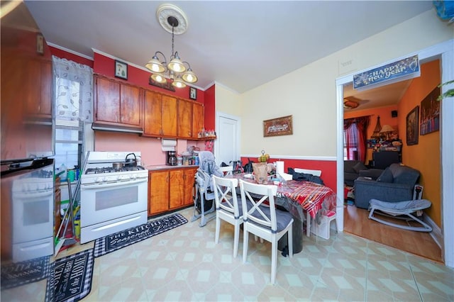 kitchen with decorative light fixtures, white range with gas stovetop, oven, and a notable chandelier