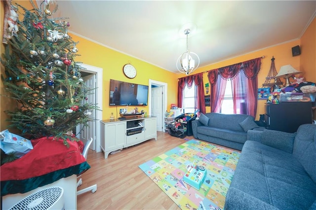 living room with ornamental molding, light hardwood / wood-style floors, and a notable chandelier