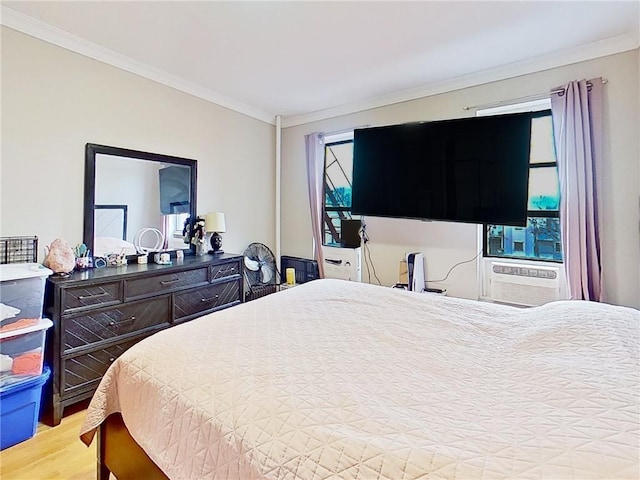 bedroom featuring cooling unit, multiple windows, crown molding, and light hardwood / wood-style flooring