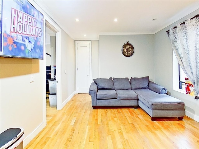 living room featuring light wood-type flooring and ornamental molding