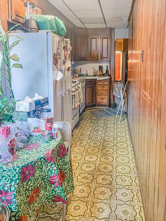 kitchen with a paneled ceiling and white appliances