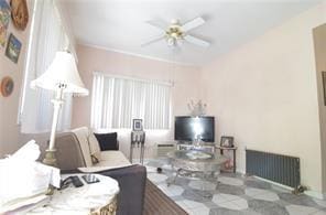 living area featuring ceiling fan and radiator