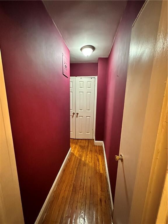 hallway with hardwood / wood-style flooring