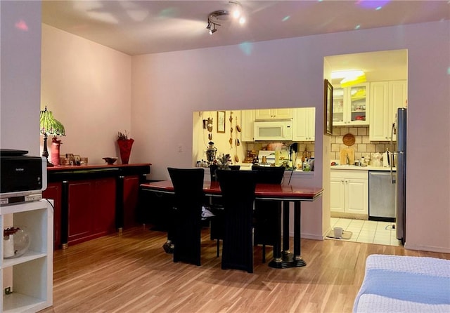 100 Oceana Dr W Unit 1G, Brooklyn, NY 11235 - bar featuring white microwave, stainless steel dishwasher, light wood finished floors, tasteful backsplash, and a sink