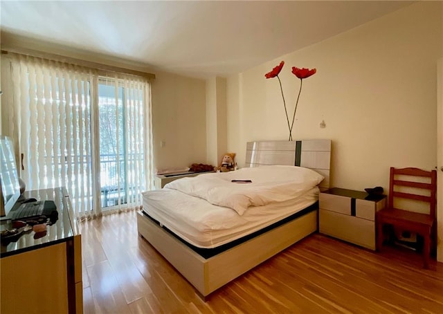 bedroom featuring hardwood / wood-style flooring and access to outside