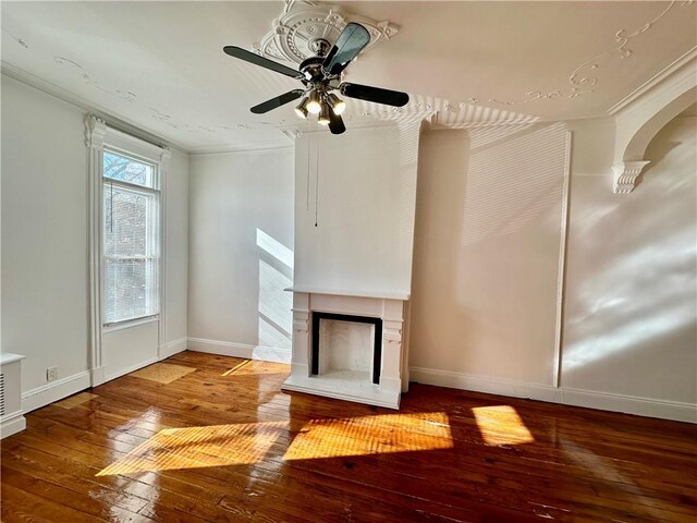 unfurnished living room with hardwood / wood-style flooring, ceiling fan, and ornamental molding