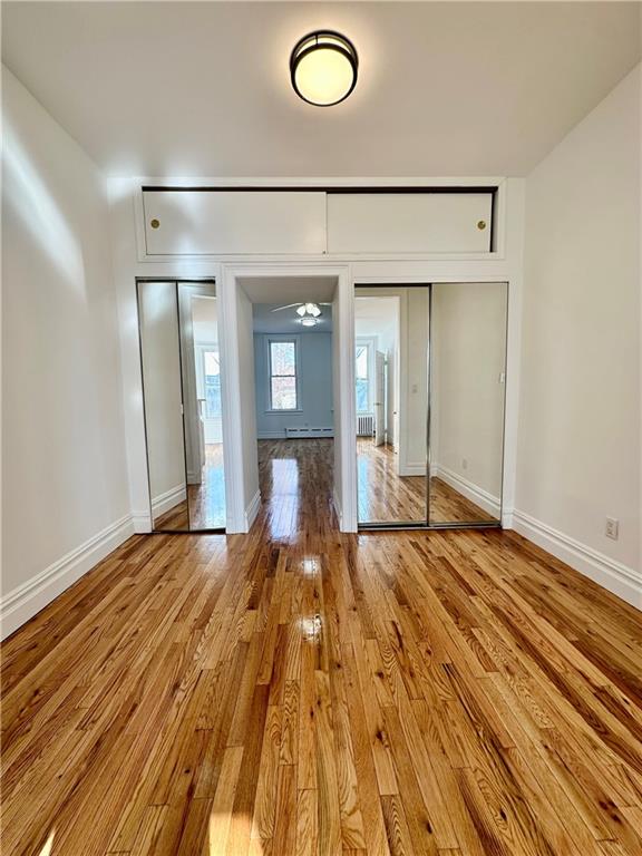 interior space with ceiling fan, light hardwood / wood-style floors, and baseboard heating